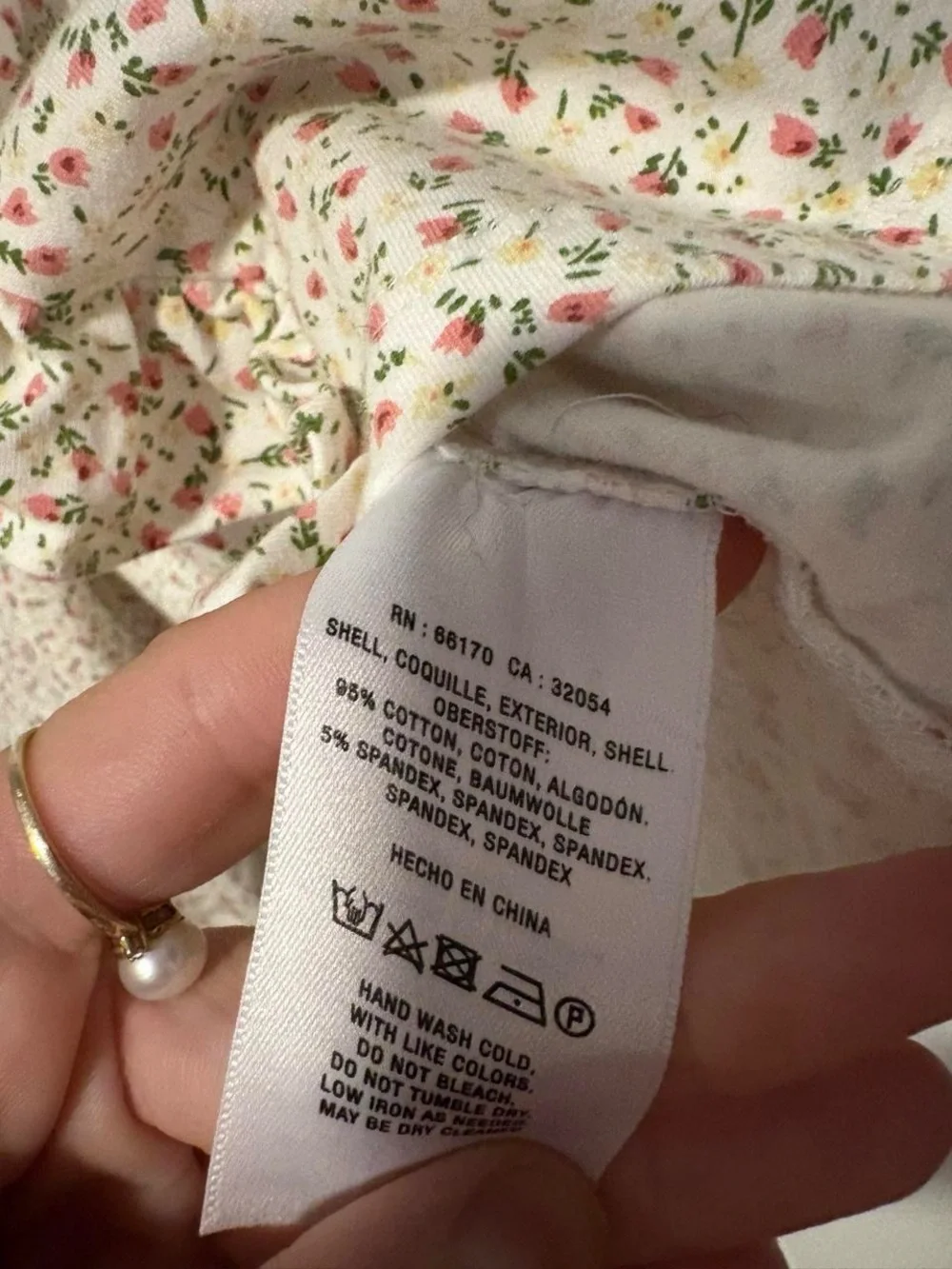 Anthropologie white cotton blouse with small pink ditzy floral print and ruffles